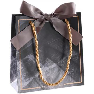 China wholesale luxury foldable shopping bag custom logo black paper gift bag with ribbon for sale