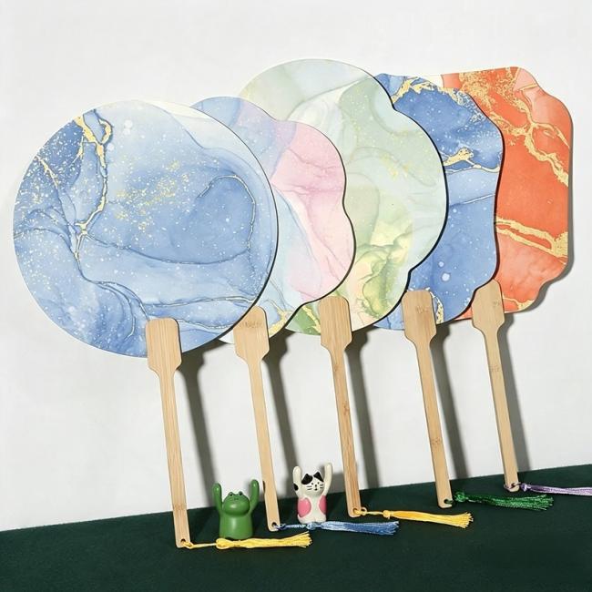 Close-up of polished wooden fan handles decorated with colorful hanging silk tassels in multiple shades
