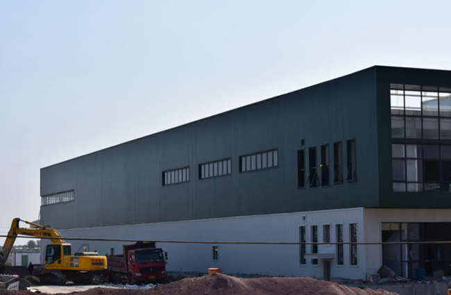 Close-up of steel sheet wall cladding installation on warehouse building