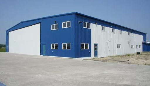Metal prefabricated building under construction with steel frame and cladding panels