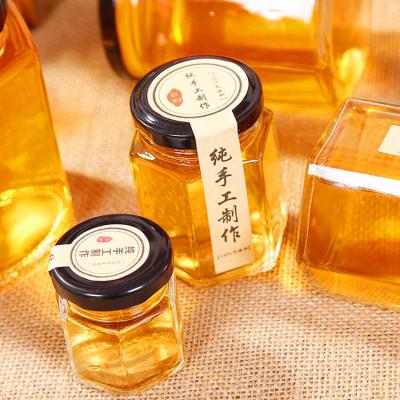 China Hexagon Clear Glass Storage Bottle 100ml 500ml With Metal Lid For Honey Cream for sale