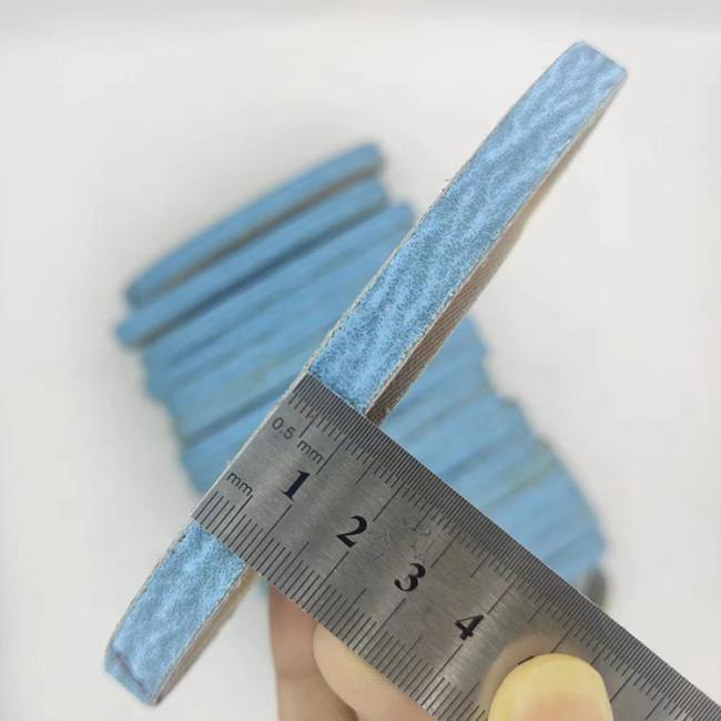Sanding belt in use on metal surface