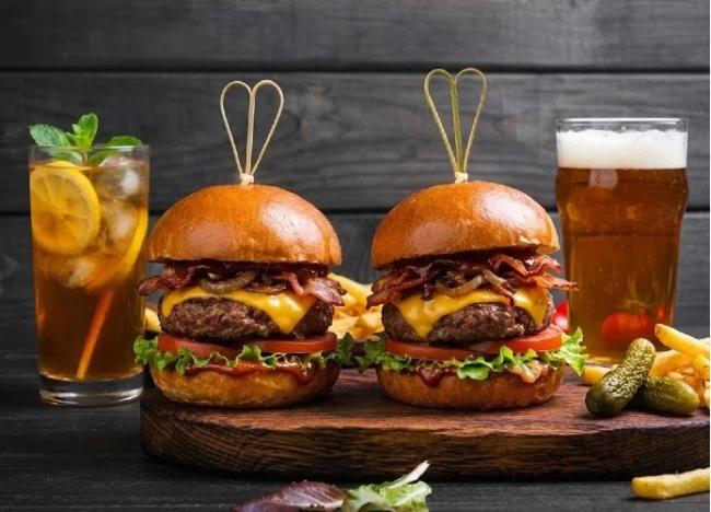 A tall gourmet cheeseburger held together firmly by a 150mm heavy-duty bamboo knot pick