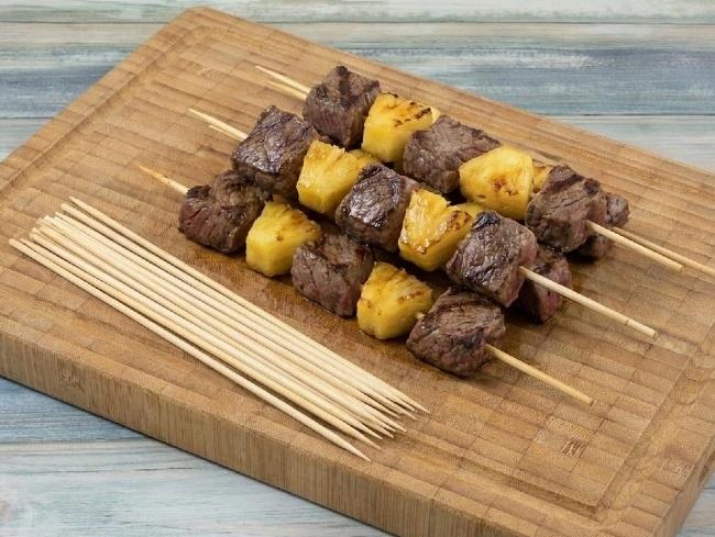 Chef grilling meat kebabs using heavy duty 10 inch bamboo skewers on charcoal grill