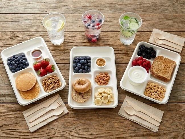Sustainable bagasse compartment plates serving hot meals in hospital and corporate cafeterias.