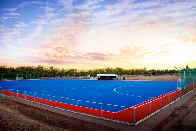 Hockey match in progress on FIH certified artificial turf surface
