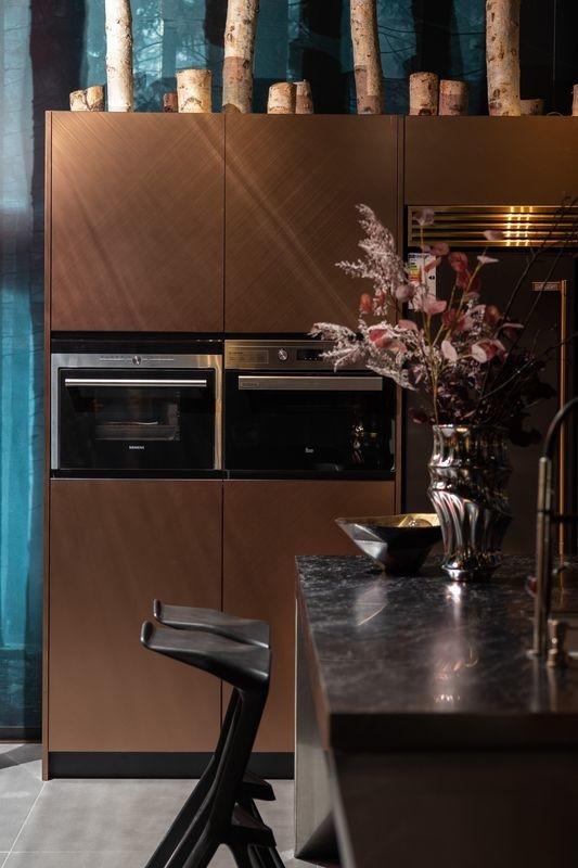 Rose Gold Modern Kitchen Cabinet With Geometric Lines And Stainless Steel Durability - A stunning combination of textured stainless steel and imported sintered stone, delivering both beauty and practicality with feature detail