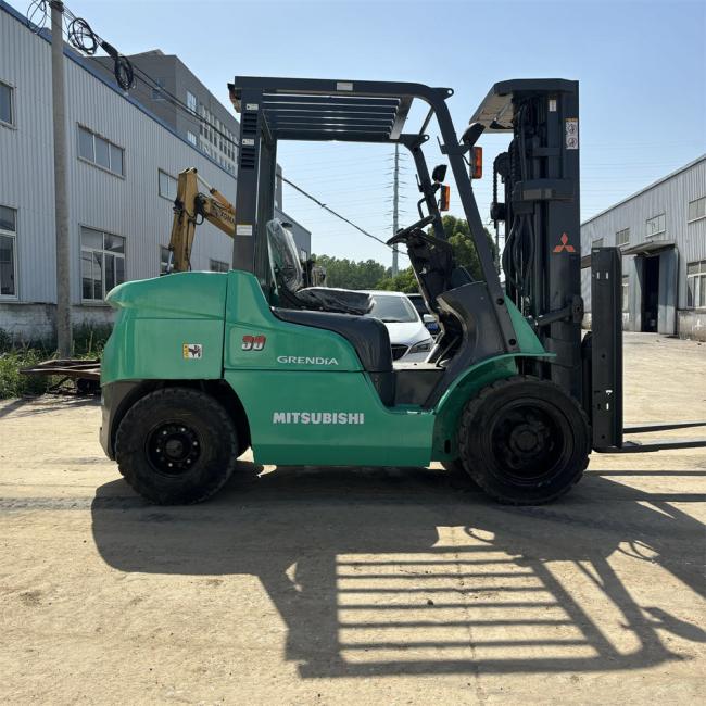 Used Komatsu electric reach stacker side view showing yellow frame and lifting mechanism