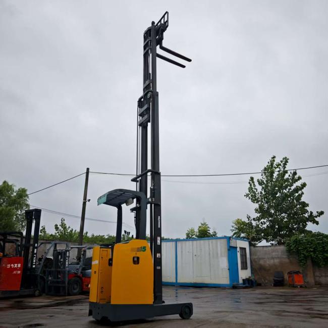 Operational view of Komatsu electric reach stacker lifting pallets in warehouse setting