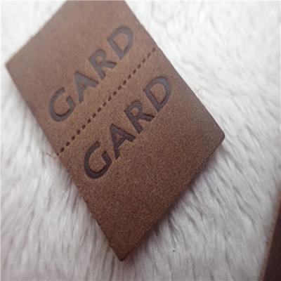 China Embossed Leather Woven Label With Dashed Points Convenient To Mid Fold for sale
