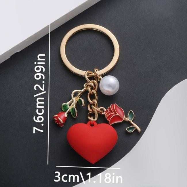 Close-up of heart-shaped rose keychain showing metal and plastic construction and red rose design