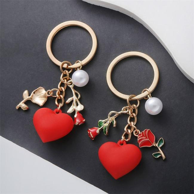 Heart-shaped rose keychain attached to a handbag as a decorative pendant