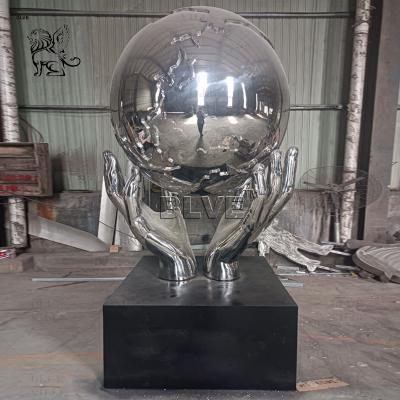 China Stainless Steel Holding Earth Sculpture Large Mirror Polished Metal World Globe Statues Decoration Outdoor Square Custom for sale