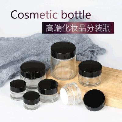 China Round Empty Glass Jar Transparent Cosmetic Jar With Black Plastic Lid for sale