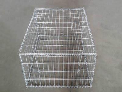 A galvanized welded gabion on the ground.