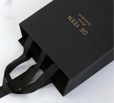 China Pequeñas bolsas de papel negras profesionales, bolsas de papel personalizadas con la manija de la cinta en venta