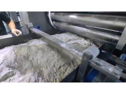 A relaxing dough loop accumulating before the first satellite multi-roller sheeting head to eliminate internal tension.