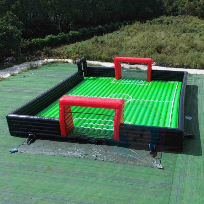 PRODUCT CORE HIGHLIGHTS · Inflatable soccer field design combines football play bouncing fun and enclosed safety structure for active group entertainment · Large custom size options support indoor halls outdoor lawns schools clubs events and commercial amusement projects · Soft inflatable walls and goal areas help create a safer play space for children teens and interactive participants · Durable PVC construction supports repeated use easy cleaning convenient storage and fast setup for rental operations · Suitable for football training family activities team games carnival programs sports events and inflatable playground business use