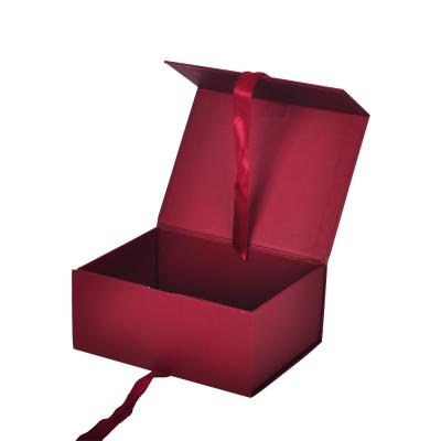 China Caixa de embalagem de papel magnético vermelho de papelão dobrável com fita à venda