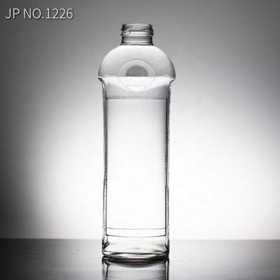 China Botella de vidrio de agua mineral de 750 ml con tapa de tornillo tipo de sellado para agua bendita en venta