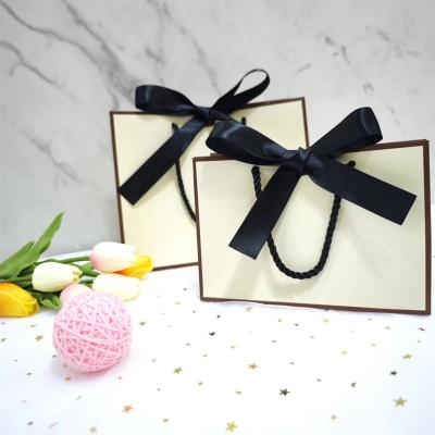 China Black Handle Pretty Pink Kraft Paper BagsWith Ribbon for sale