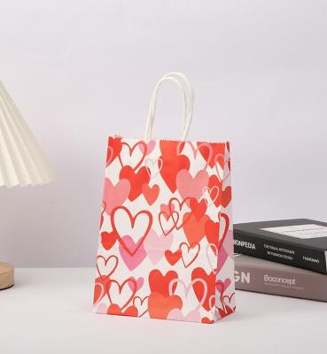 China Red 80gsm Kraft Paper Gift Bags Love Heart Printed Paper Goodie Bags With Handles for sale