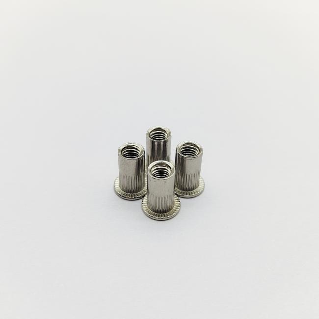 Knurled flat head rivet nuts close-up