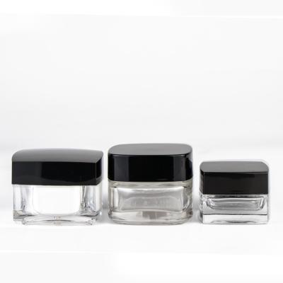 China Eco - Friendly Glass Cosmetic Cream Jar Square Shape Clear Body Black Lid for sale
