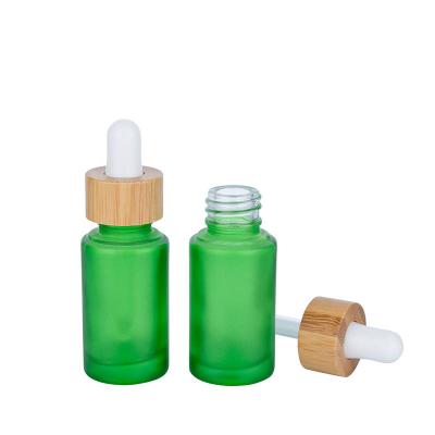 China Botellas de gotero de vidrio verde helado de 30 ml Botella de aceite esencial con gotero de bambú en venta