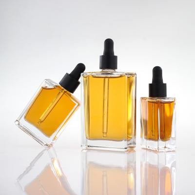 China Flat Square Serum Glass Dropper Bottles 30ml 50ml 100ml With Black Gold Collar for sale