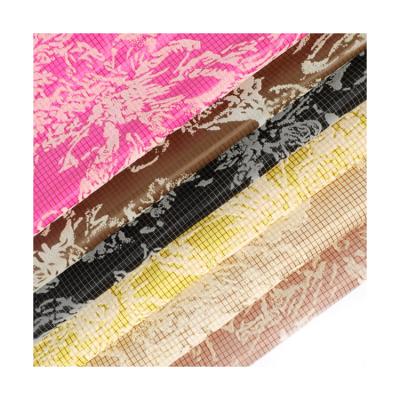 China Manufacturers direct tartan silk spinning flower can be customized pattern flocking down down jacket fabric à venda