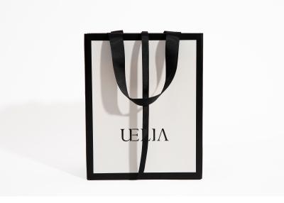 China Kundenspezifische Einkaufs-Papiertüte druckte weiße Carry Bags Luxury Boutique Paper-Tasche für Kleidung mit Ihrem eigenen Logo zu verkaufen