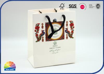 中国 190gsmクリスマスの御馳走袋のためのリボンのハンドルが付いている固体着色されたアート ペーパーのギフト袋 販売のため