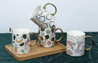 中国 New bone china mug with electroplating handgrip for home/office using fashion ceramic design 販売のため