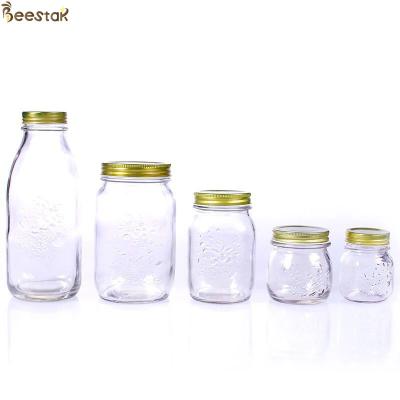 China Carved Flower Honey Glass Jar And Spoon Transparent Honey Container for sale
