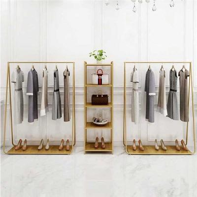 China Modern Boutique Gold Metal Shelves Clothing Store Display Rack for sale