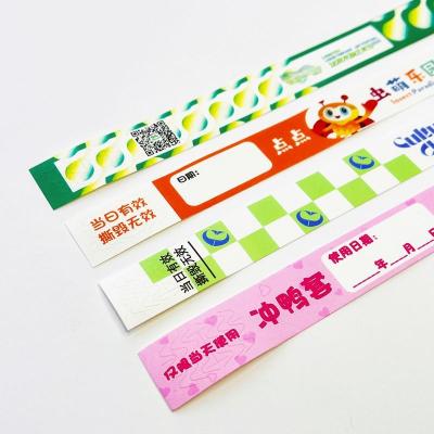 中国 Custom Full Color Waterproof Tyvek Paper Wristbands with Snap Closure and Custom Logo 販売のため