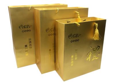 China Custom Luxury Printed Gold Paper Gift Bags With Embossed Logo Tassel Handles for sale