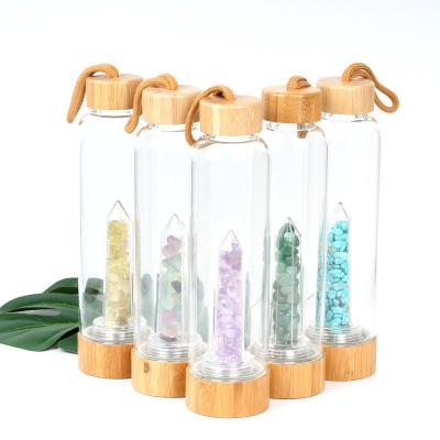 China Botella de agua de cristal redonda con el punto cristalino natural del cristal del elixir del centro de la piedra preciosa en venta