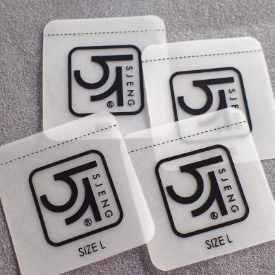 China Las etiquetas suaves transparentes CMYK de la ropa de TPU colorean lavable para el traje de baño en venta