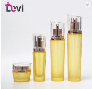 China 120ml Yellow Cosmetic Shape Lotion Glass Bottle With Acrylic Cream for sale