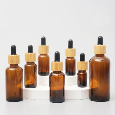 China Glossy Amber Color Bamboo Essential Oil Glass Dropper Bottle Wood Cap Glass Cosmetic Containers for sale