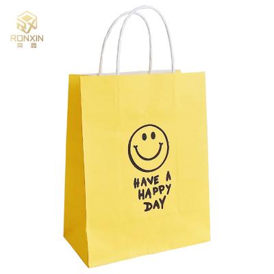 China 26cm Height Coated Yellow Paper Gift Bags Reusable With Smile Face for sale