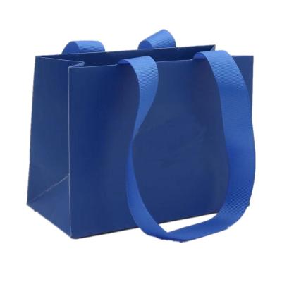 China Las bolsas de papel planas multiusos de la manija, las compras de papel reutilizables empaquetan azul en venta
