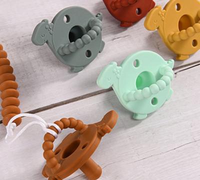 China Food Silicone Baby Pacifier Dinosaur Head Orthodontic Nipple for sale