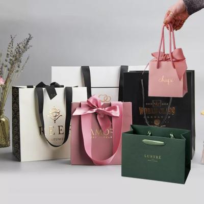 China Grosgrain Handle Matte Black Paper Bag Gold Hot Stamping Retail Paper Shopping Bag for sale