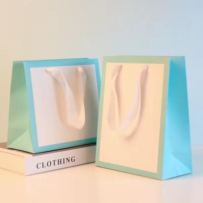 China Foldable Stand Up Ribbon Closure Kraft Paper Bags Paper Bag Packaging For Clothes for sale