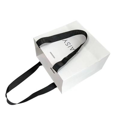 China Prägungsband-Griff-kosmetische Papiertüte-Weißbuch-Fördermaschinen-Taschen zu verkaufen
