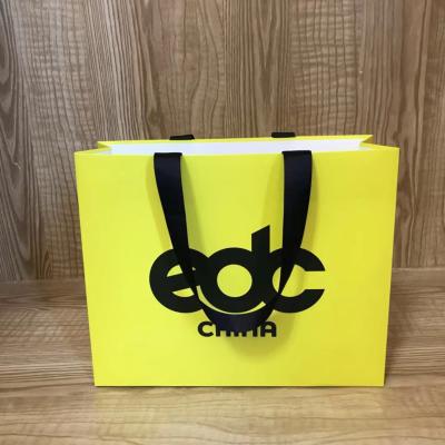China 175gsm Lotus Color Goose Yellow Garment Paper Bags For Clothing Store for sale