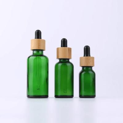 Chine le compte-gouttes en verre vert d'huile essentielle de 100ml 50ml 30 ml 15ml met le pot en bouteille cosmétique de couvercle en bambou de compte-gouttes d'oeil à vendre